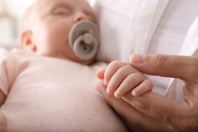 Photo of Mother with her cute sleeping baby, closeup of hands