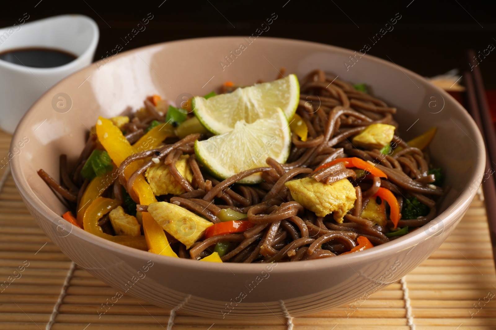 Photo of Stir-fry. Delicious cooked noodles with chicken and vegetables in bowl on table, closeup