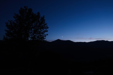 Silhouette of mountains against beautiful sky at night