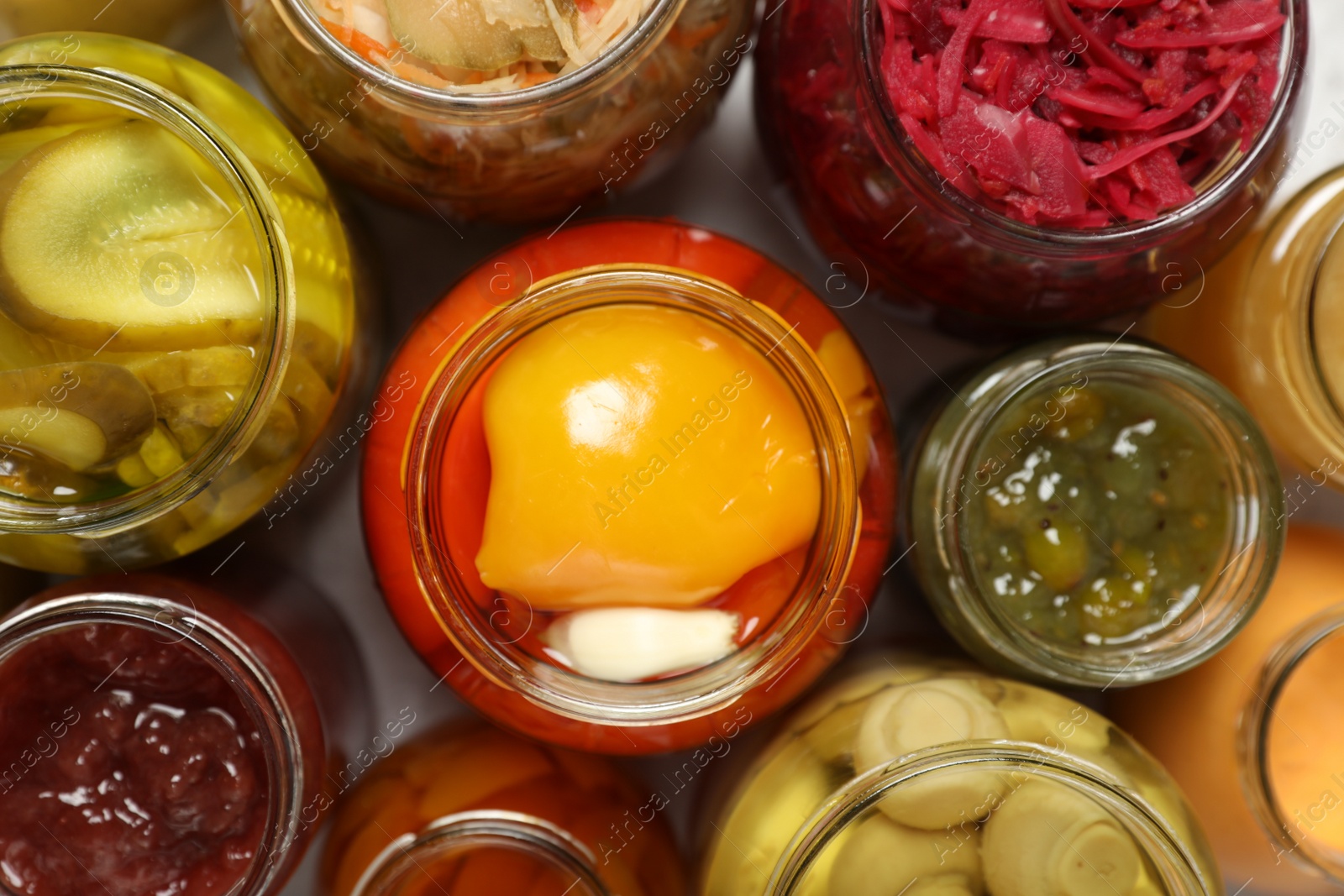 Photo of Many jars with different preserved products on white table, flat lay