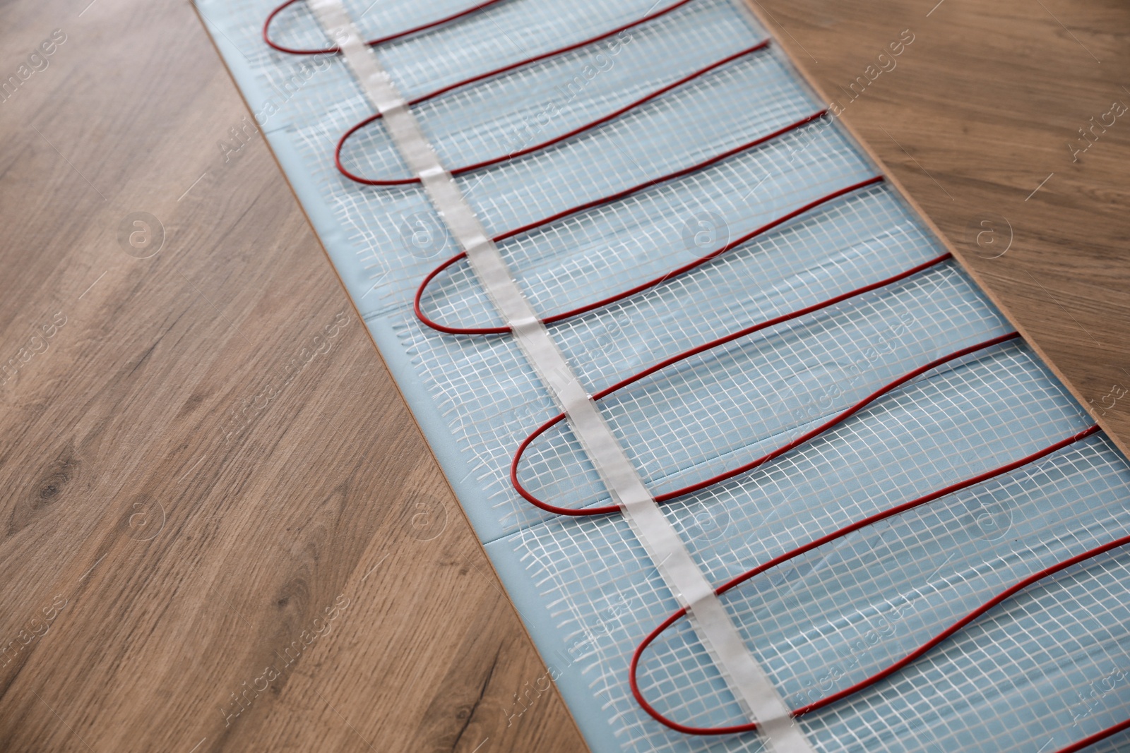 Photo of Installation of modern underfloor trace heating system indoors