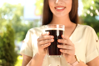 Photo of Young woman with cold kvass outdoors, closeup. Traditional Russian summer drink