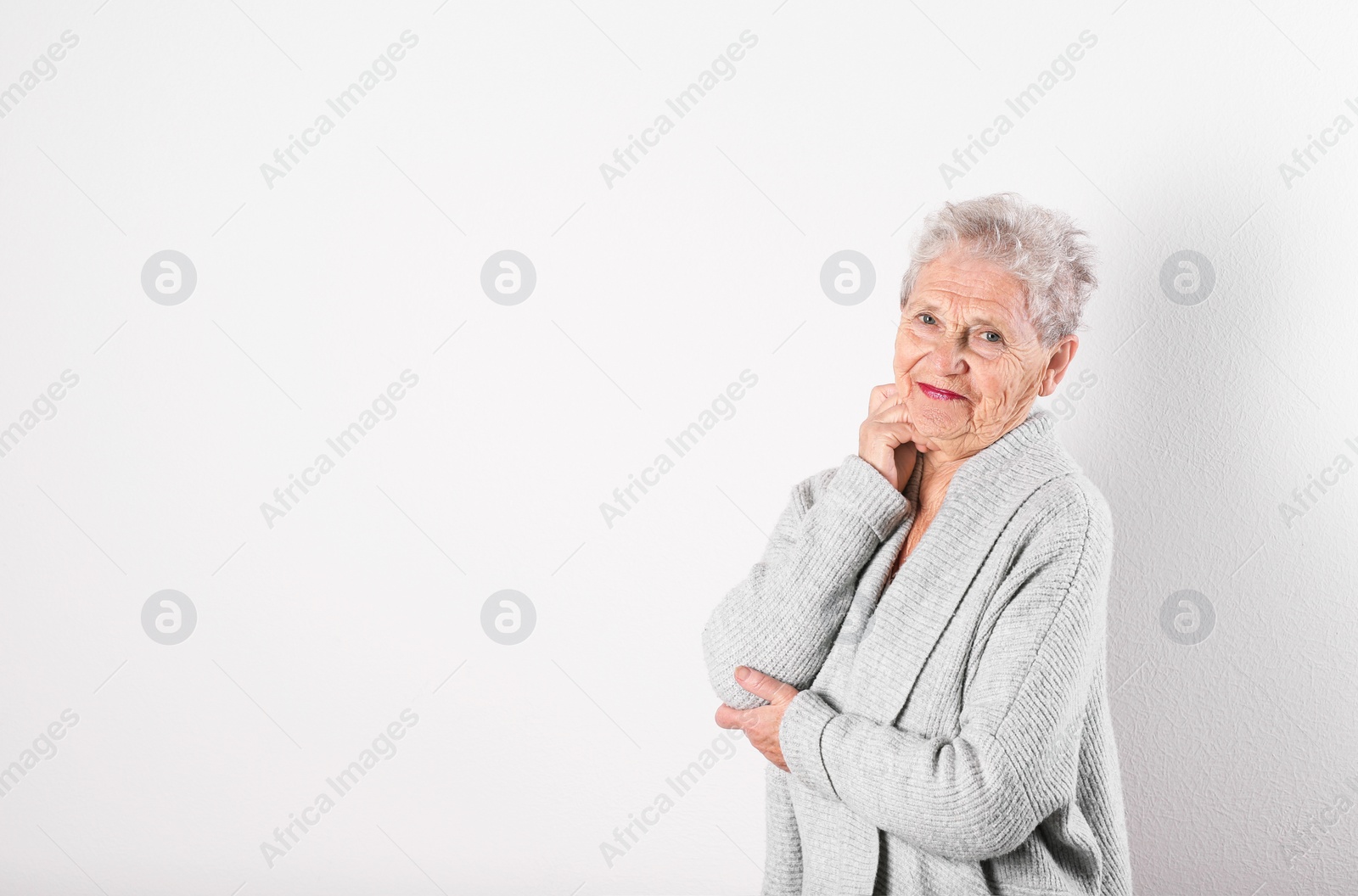 Photo of Portrait of grandmother in stylish clothes on light background, space for text