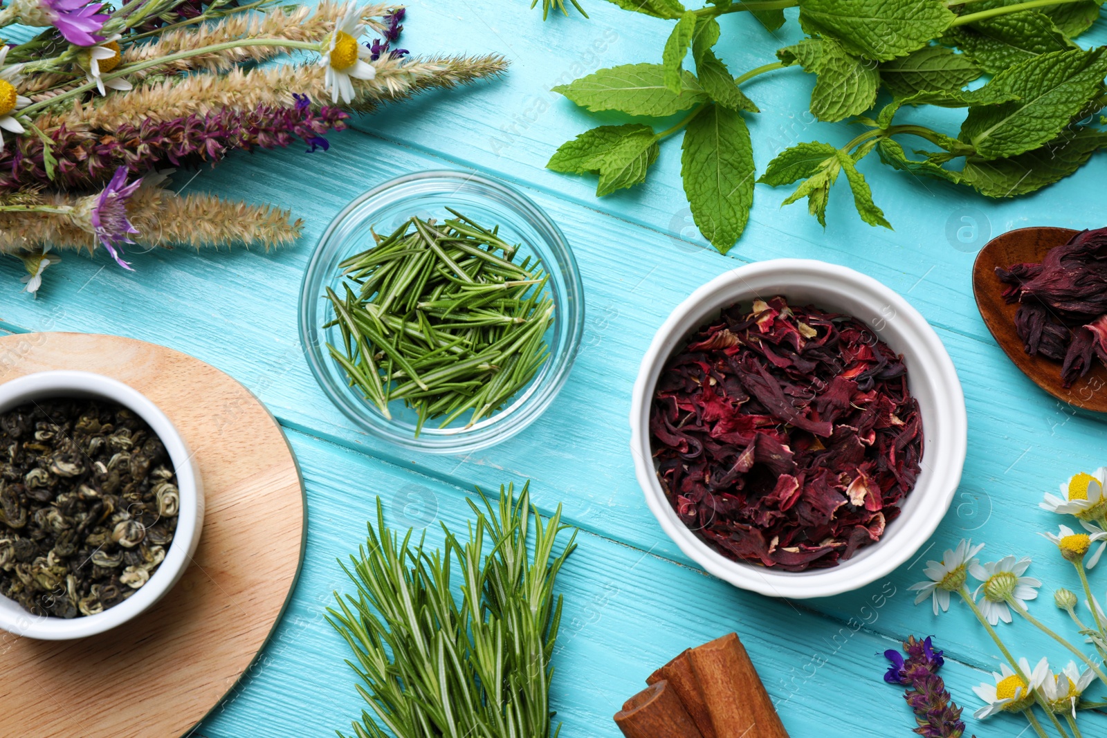 Photo of Flat lay composition with healing herbs on light blue wooden table