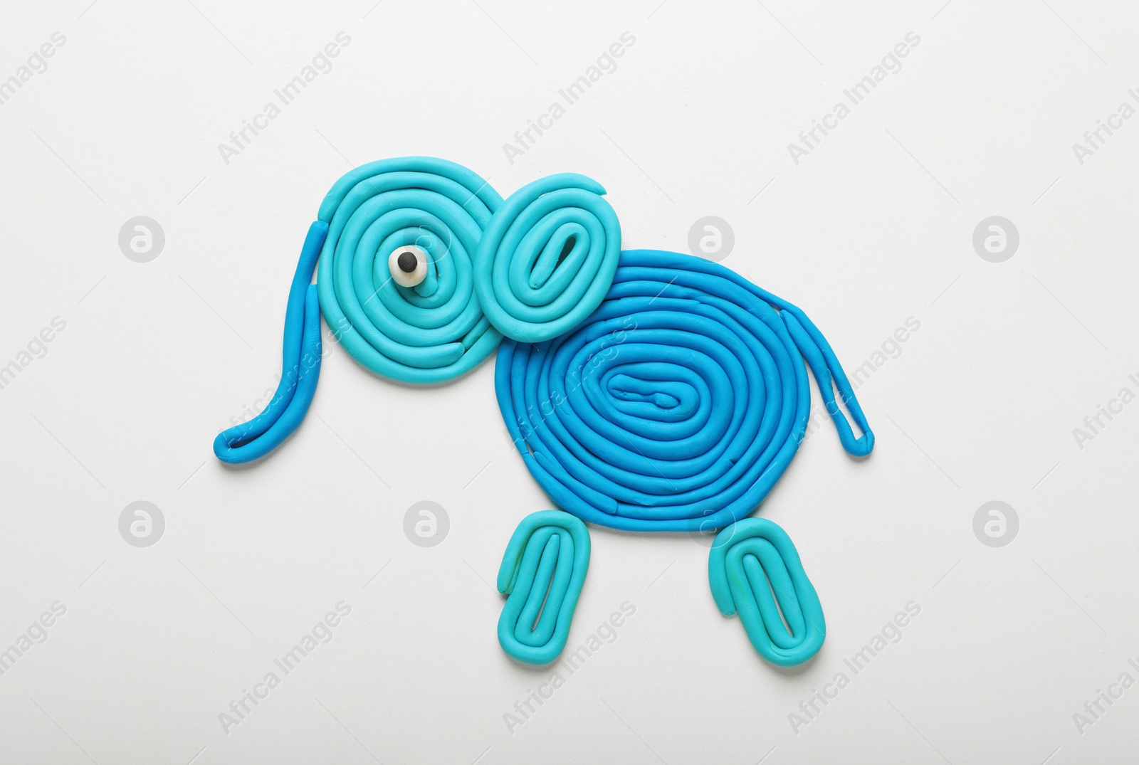 Photo of Light blue plasticine elephant isolated on white, top view