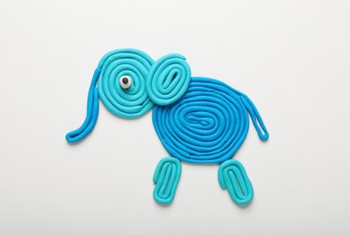 Photo of Light blue plasticine elephant isolated on white, top view
