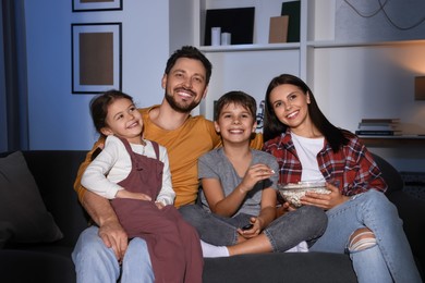 Happy family watching TV at home in evening