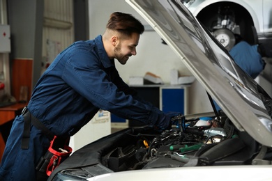 Photo of Technician checking modern car at automobile repair shop