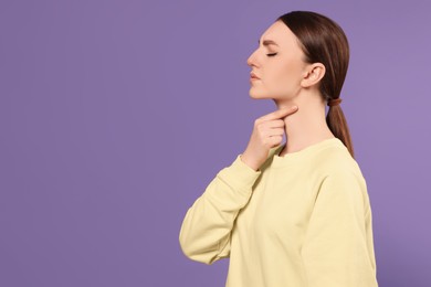 Young woman with sore throat on violet background. Space for text