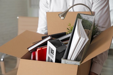 Young man with box of stuff in office, closeup