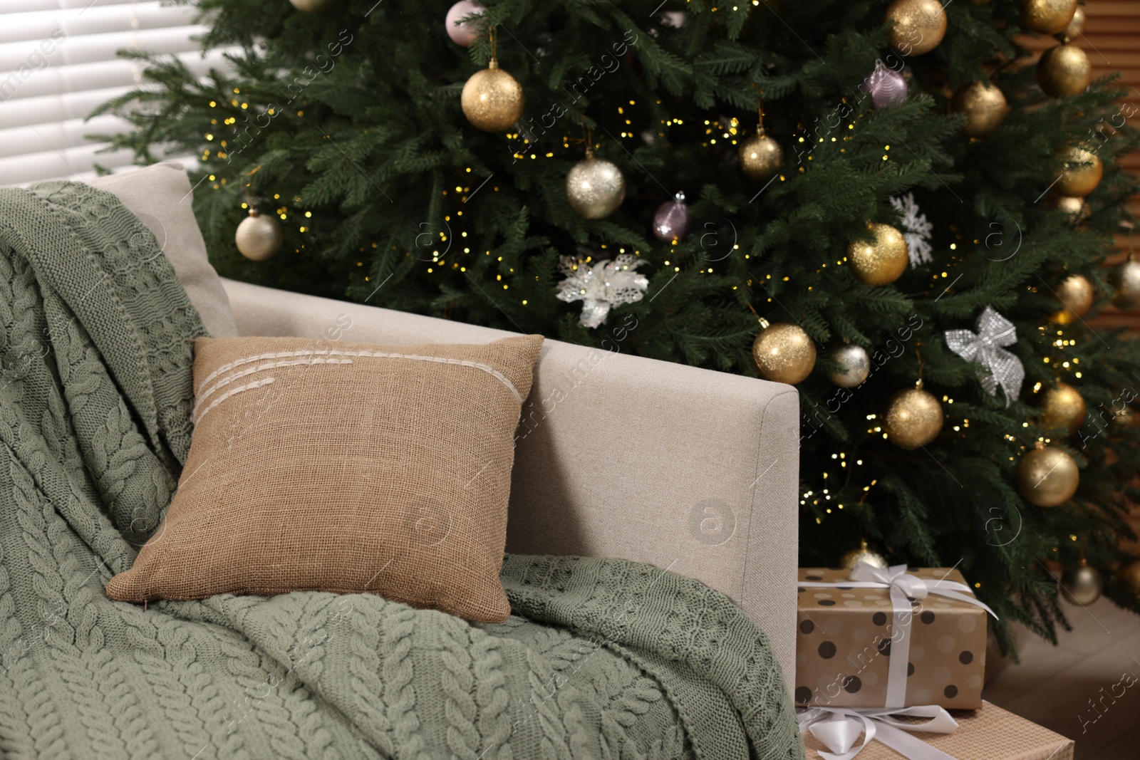 Photo of Sofa near Christmas tree in room. Festive interior design