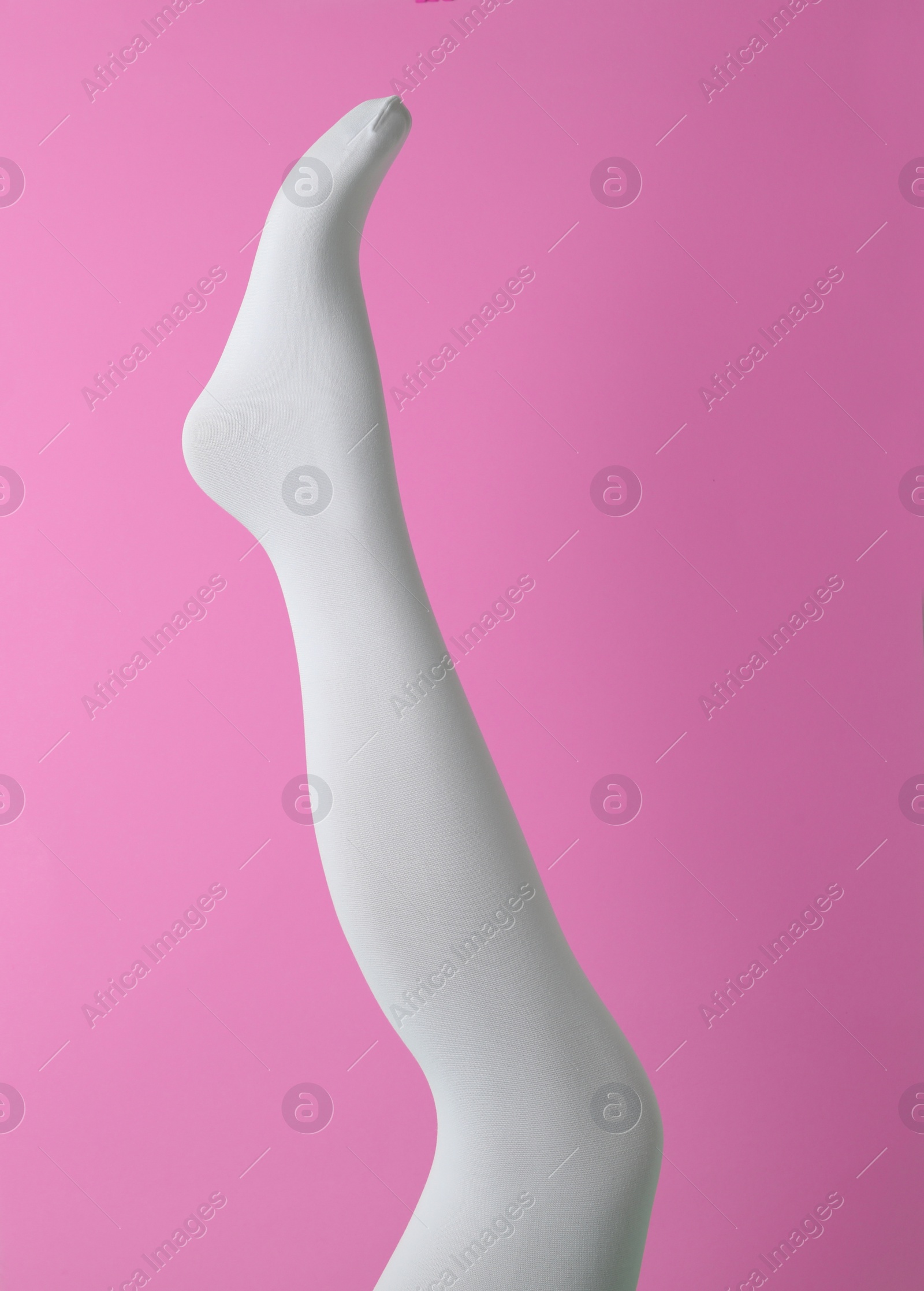 Photo of Leg mannequin in white tights on pink background