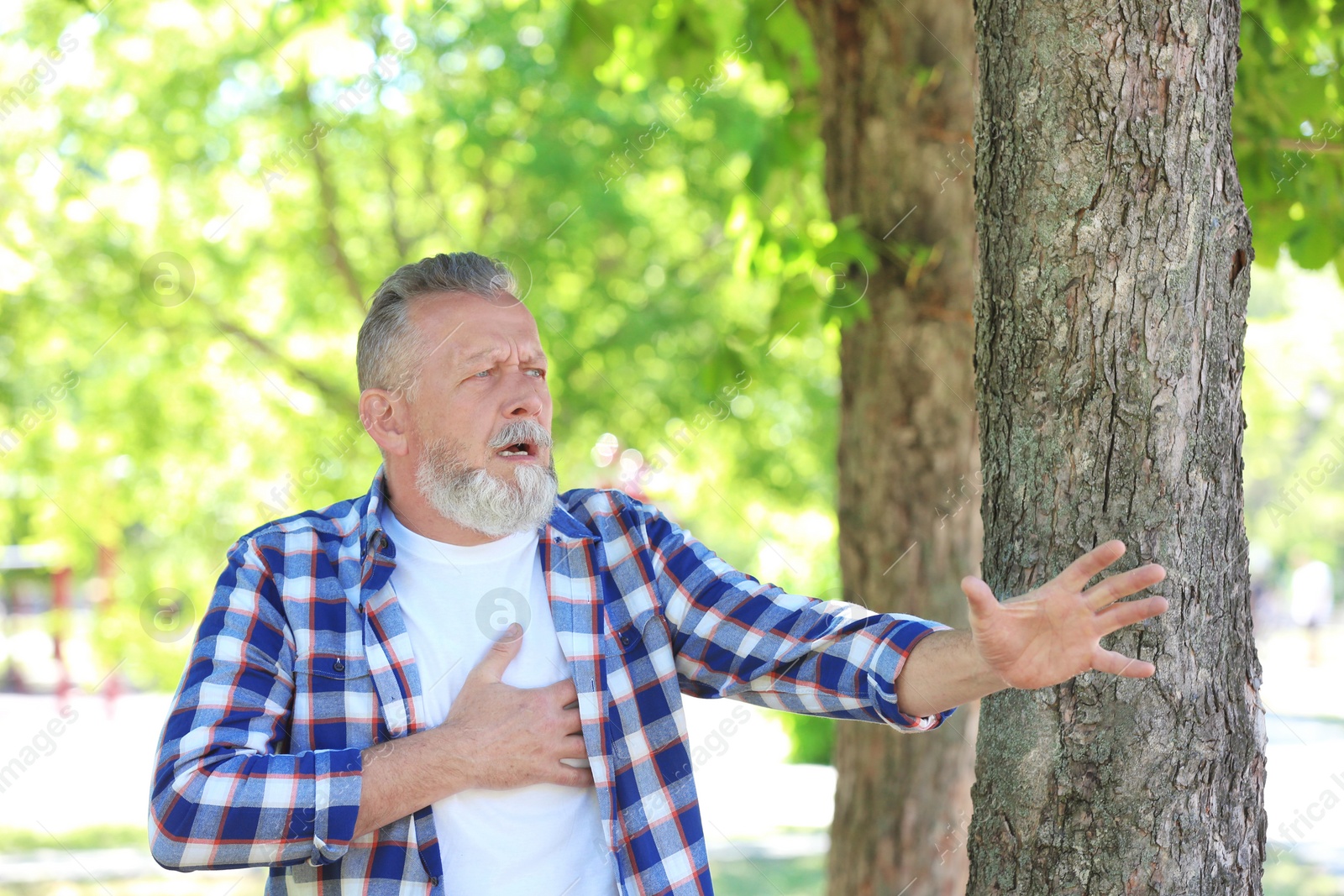 Photo of Mature man having heart attack in park