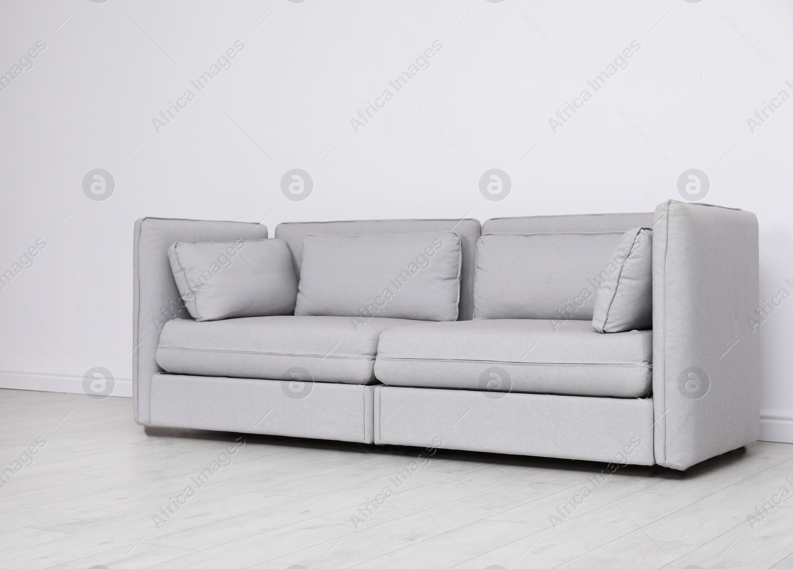 Photo of Room interior with comfortable sofa near white wall