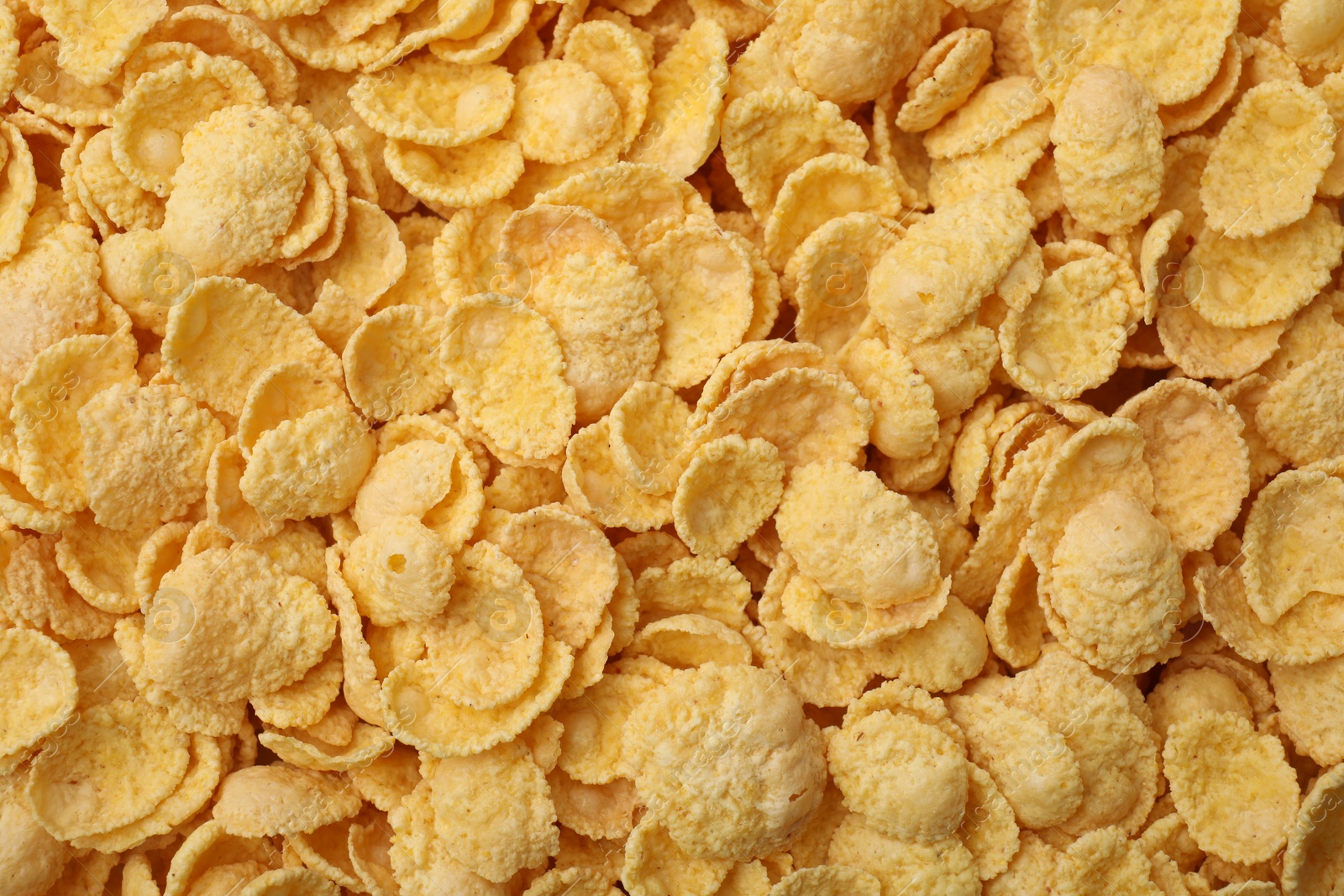 Photo of Breakfast cereal. Tasty sweet corn flakes as background, top view