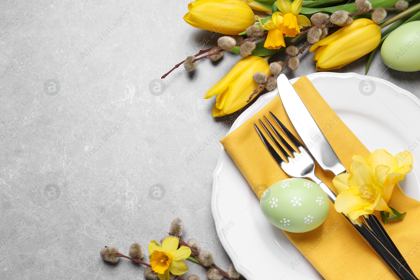 Photo of Festive Easter table setting with eggs on grey background, flat lay. Space for text