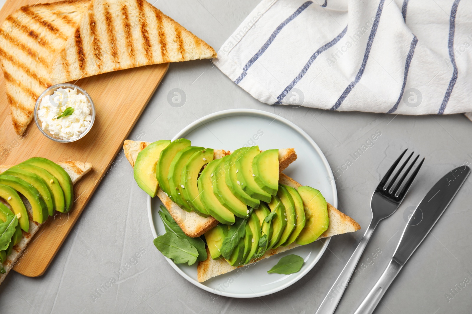 Photo of Flat lay composition with avocado toasts on grey table