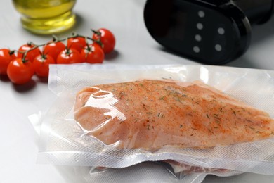 Photo of Vacuum packing with meat on white table, closeup. Sous vide cooking