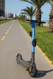 Photo of Modern electric scooter outdoors on sunny day. Rental service