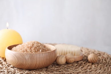 Photo of Salt for spa scrubbing procedure and wooden balls on table against grey background