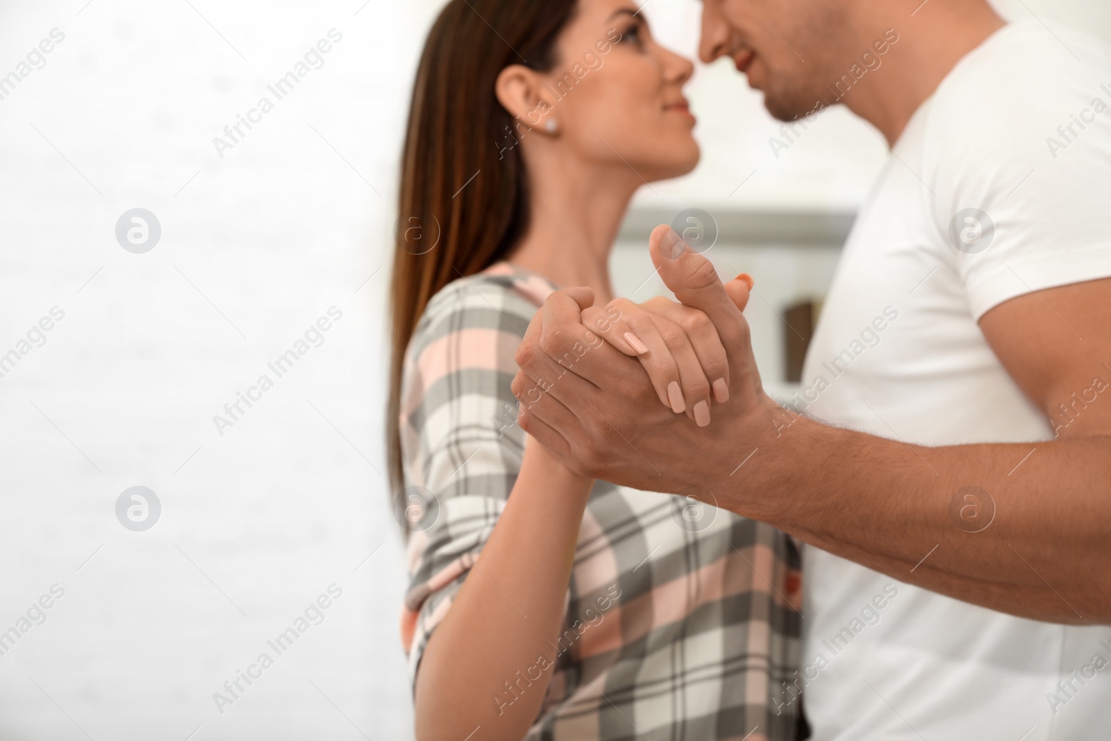 Photo of Happy young couple dancing at home, focus on hands