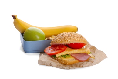 Photo of Tasty sandwich and lunch box with fruits on white background