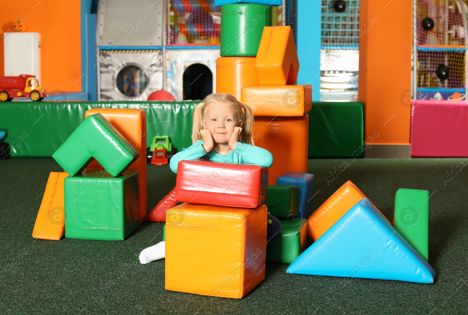 Photo of Cute child playing with colorful building blocks indoors