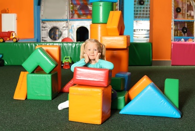 Cute child playing with colorful building blocks indoors