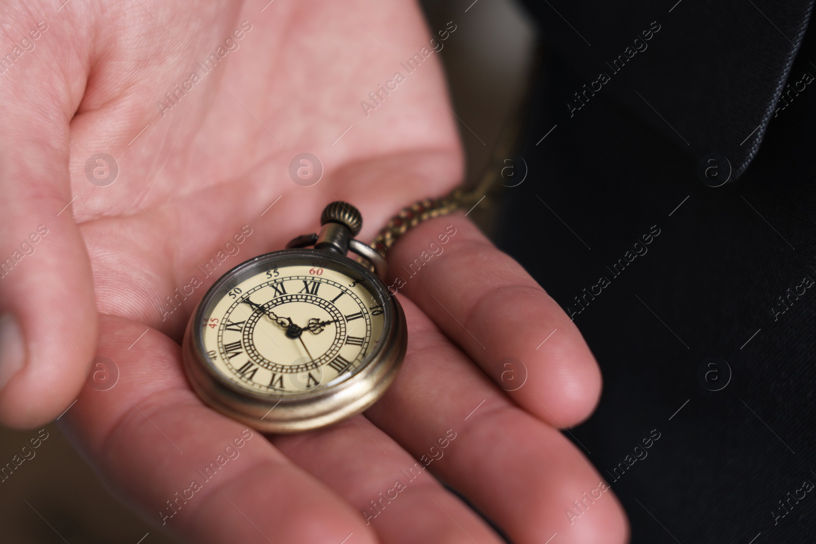 Photo of Man holding chain with elegant pocket watch, closeup