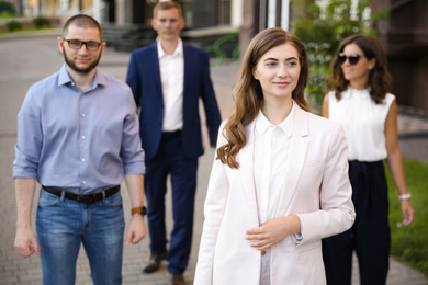 Photo of Different people walking on modern city street