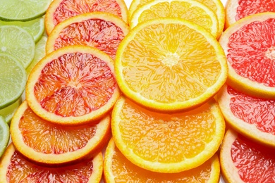 Slices of fresh citrus fruits as background, closeup