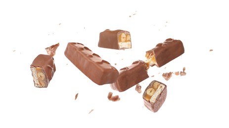 Image of Whole and broken chocolate bars with caramel, nuts and nougat falling on white background