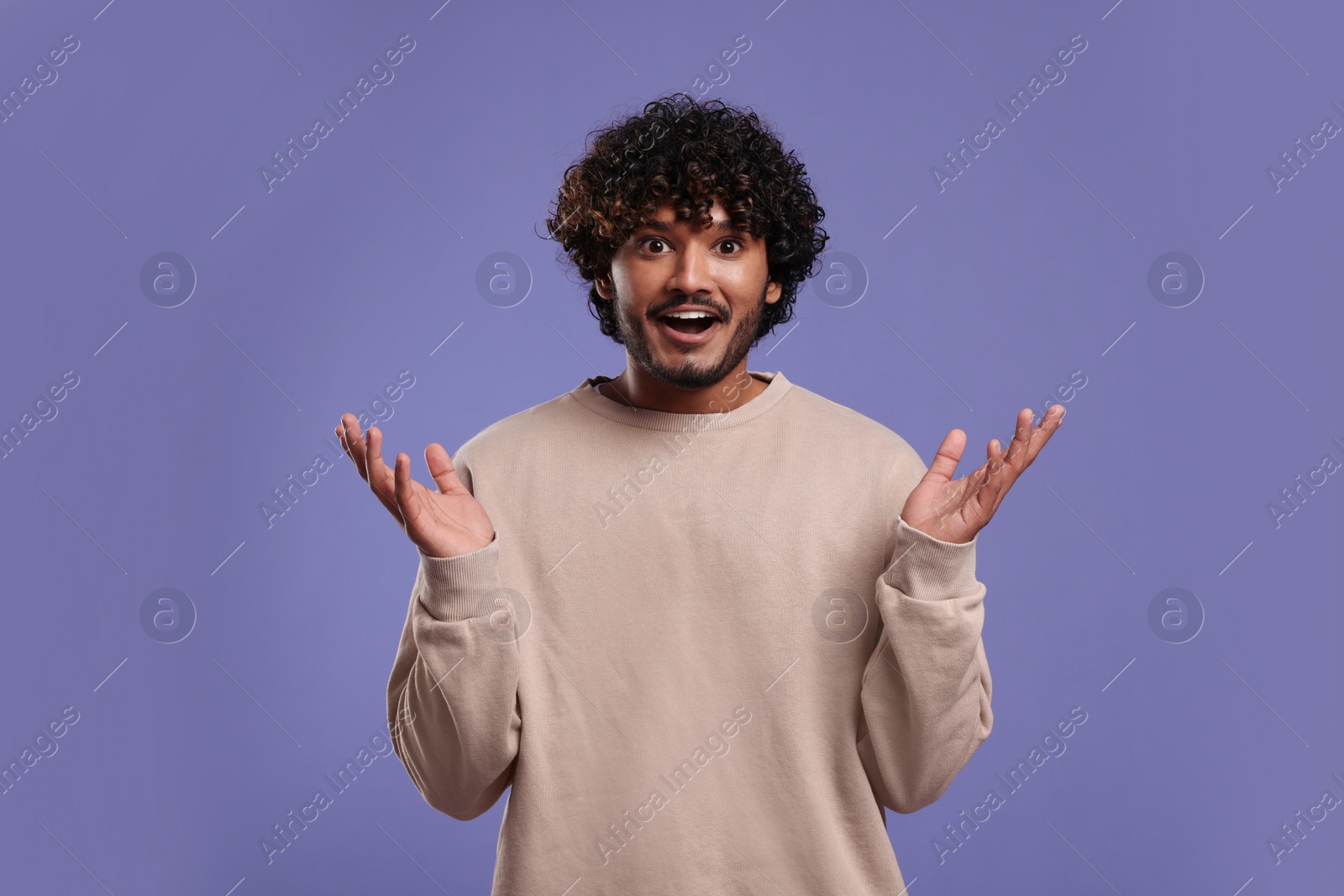 Photo of Handsome surprised man on violet background, space for text