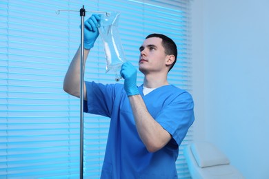 Photo of Nurse setting up IV drip in hospital