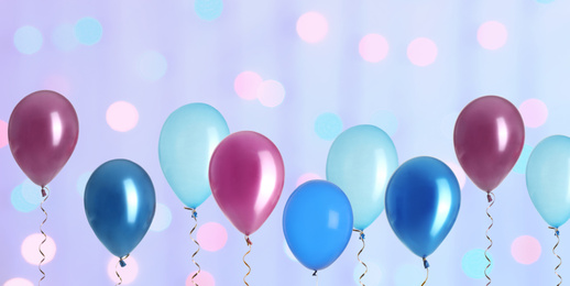 Image of Bright balloons on color background with bokeh effect. Banner design