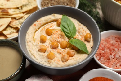 Photo of Delicious creamy hummus with chickpeas and different ingredients, closeup
