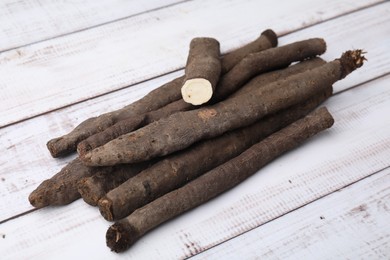 Raw salsify roots on white wooden table