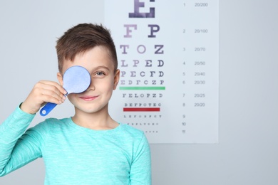 Cute little boy visiting children's doctor, space for text. Eye examination