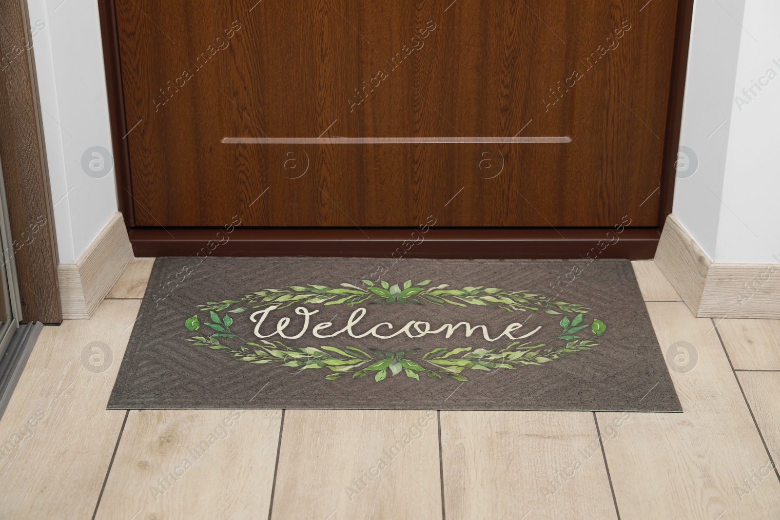 Photo of Beautiful doormat with word Welcome on floor near entrance