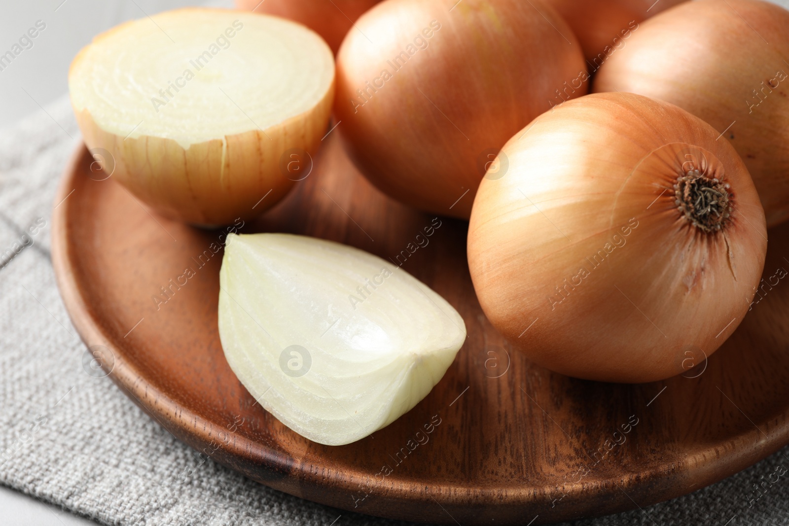 Photo of Whole and cut onions on table, closeup