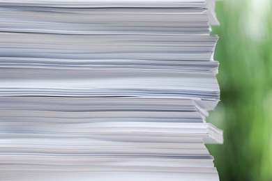 Stack of paper sheets against blurred background, closeup