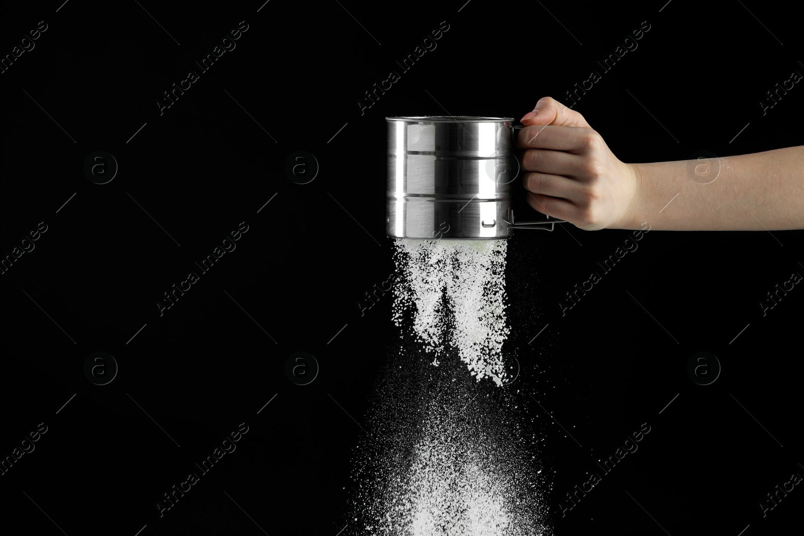 Photo of Woman sieving flour against black background, closeup. Space for text