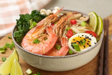 Photo of Delicious ramen with shrimps and egg in bowl on table, closeup. Noodle soup