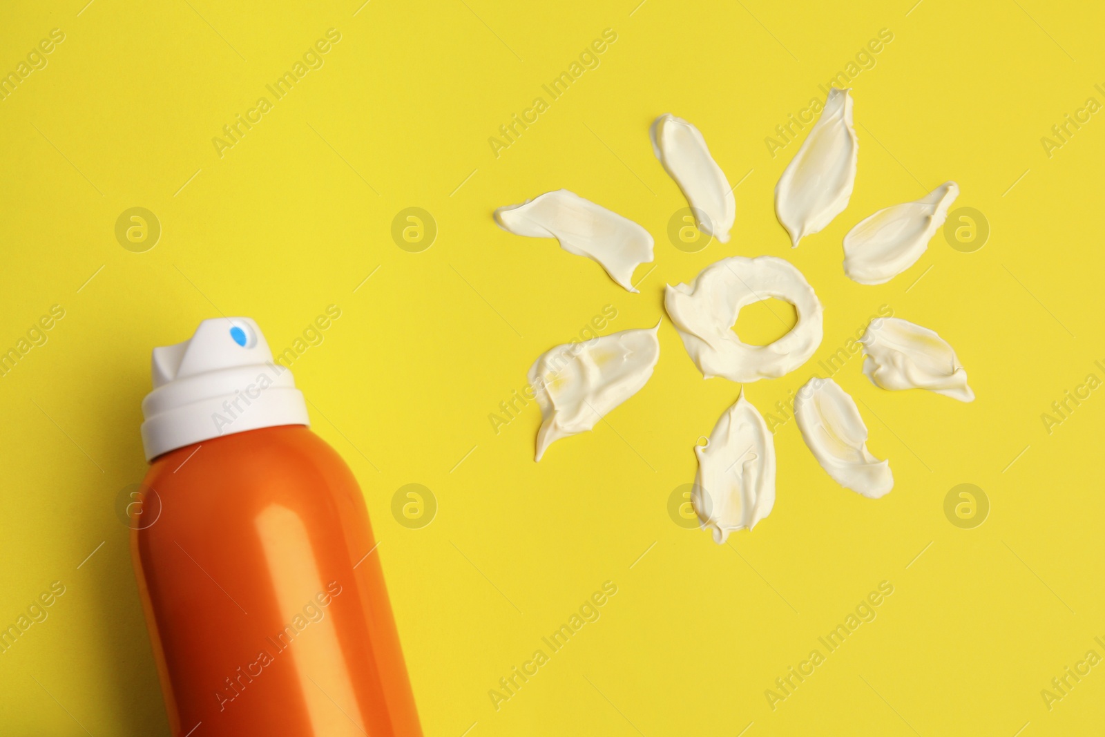 Photo of Drawing of sun and bottle with sunscreen on yellow background, top view. Skin protection