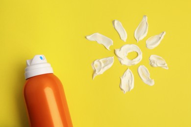 Photo of Drawing of sun and bottle with sunscreen on yellow background, top view. Skin protection