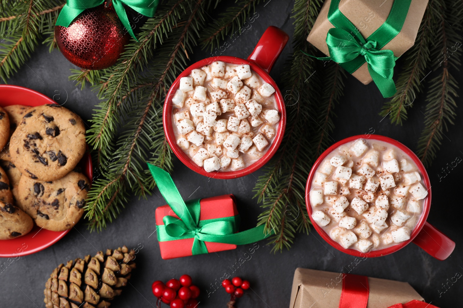 Photo of Flat lay composition with cups of delicious hot cocoa on black table