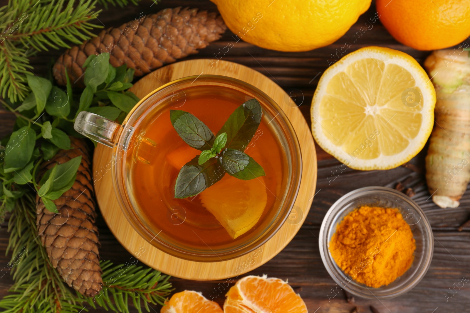 Photo of Flat lay composition with glass cup of delicious immunity boosting tea and ingredients on wooden table