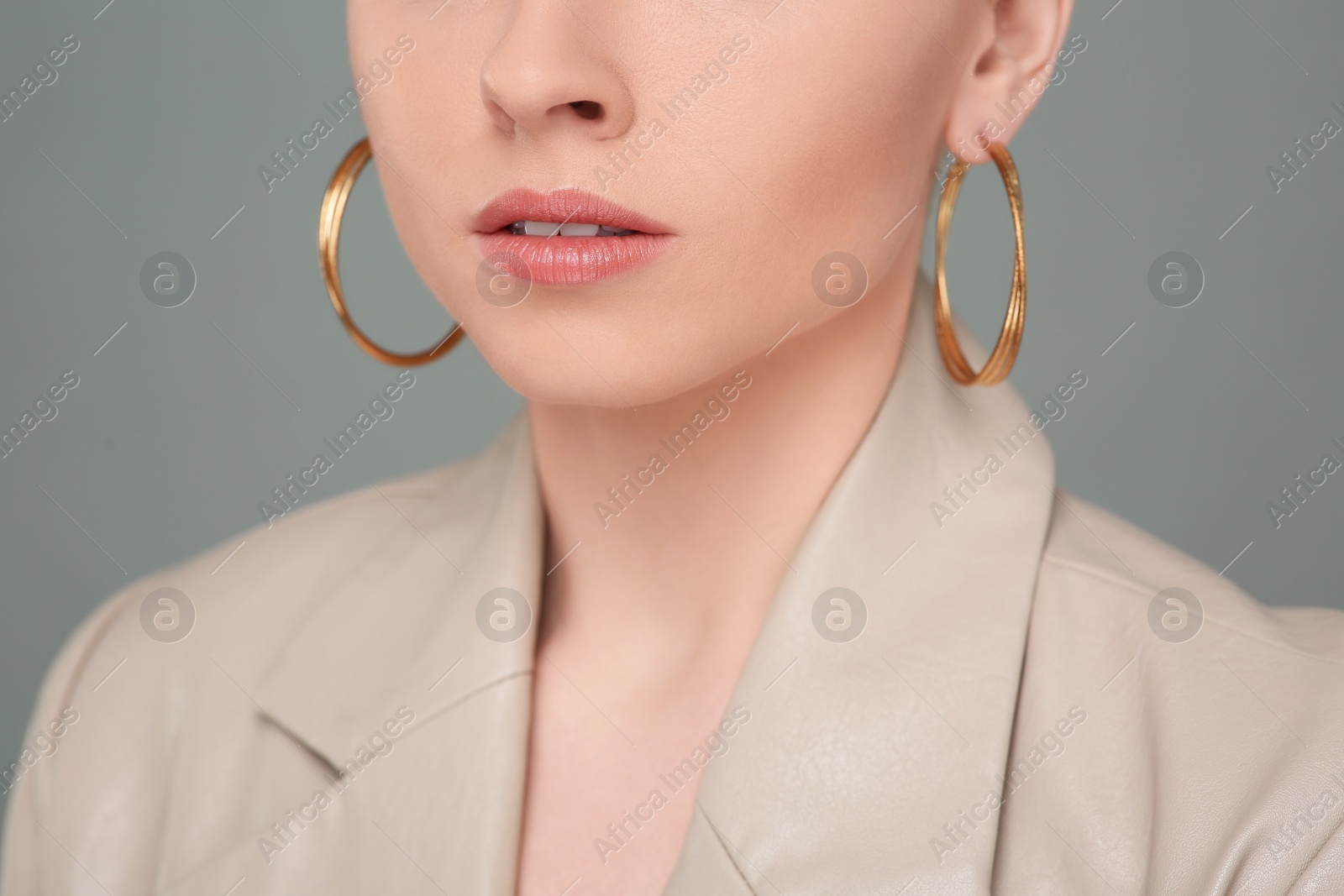 Photo of Woman with elegant earrings on gray background, closeup