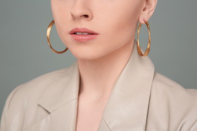 Photo of Woman with elegant earrings on gray background, closeup