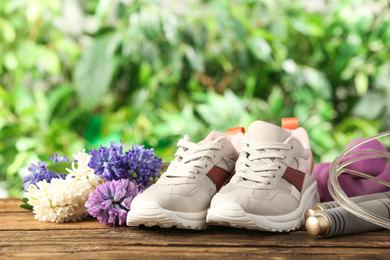 Photo of Composition with spring flowers and sports items on blurred green background